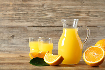 Tasty orange juice, fresh fruits and green leaf on wooden table