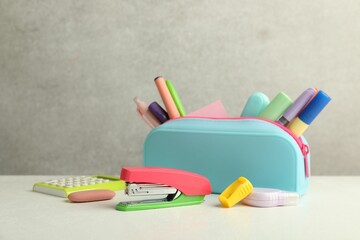 Stapler, pencil case and other different stationery on white table
