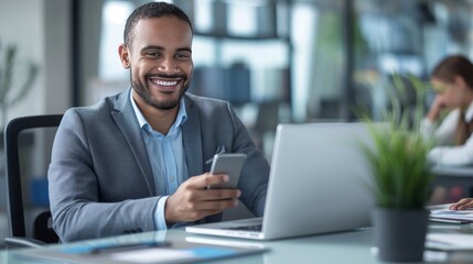 Fototapeta premium Smiling business professional using mobile phone at desk