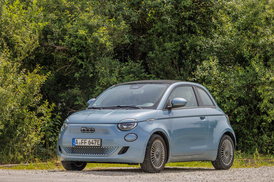 Blue Fiat 500 electric convertible in the car park of the Chapel of Saint Joseph and Blessed Adolph Kolping in Germany, Bobingen, 20.6.2024
