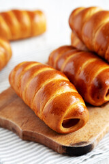 Homemade Kolache Rolls on a rustic wooden board, side view.