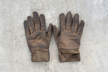 Set of leather gloves with padded fingers, neatly arranged on a construction site, showcasing durability and safety in industrial work
