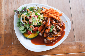 A plate of food with a salad and meat on it
