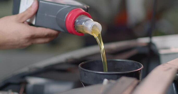 Add new engine oil to the engine. Extreme close up.New engine oil golden yellow.Footage 60P