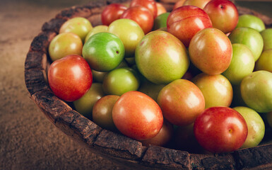 cherry plum tkemali, fruit, plum variety, in a wooden plate, Georgian cuisine, top view, no people,