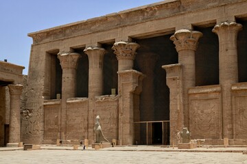 Fototapeta premium Ancient Temple of Horus with statues and tall columns under a clear blue sky in Egypt.