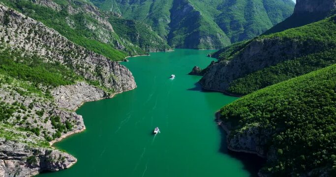 Aerial view of boats in Komani lake heading towards the beautiful mountains of northern Albania. 