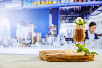Ice coffee on wooedn tray on table top in a restaurant. Blurred bar, restaurant blue background