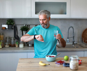 kitchen man healthy morning mature breakfast active fitness technology app watch smart smart watch...