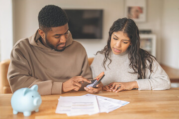 Young Couple Discussing Finances While Using Calculator at Home