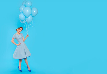 Woman in Blue Dress Holding Balloons Against Blue Background