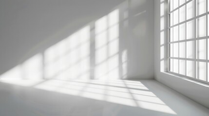 A minimalist room with a large window, showcasing sunlight casting soft shadows on the white walls and floor.
