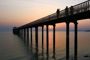 Fototapeta premium Magnificent sunrise with beautiful sky in the background of the fishing bridge in Arabian sea 
