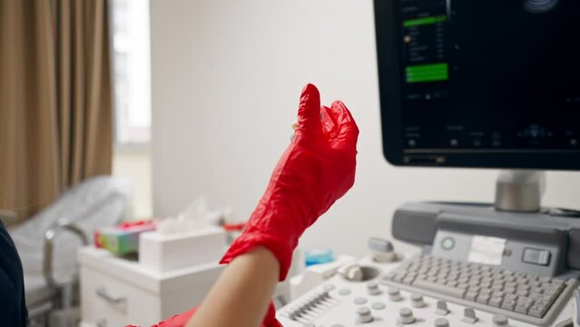 close-up in the clinic gynecological office ultrasound machine doctor puts on a condom