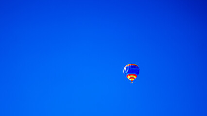 Colorful air balloon flying in the clear blue sky. High quality photo. Copy space