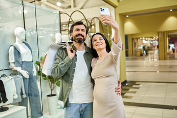 Obraz premium A joyful couple, amid a bustling shopping mall, embraces for a selfie, capturing their shared moments of happiness.