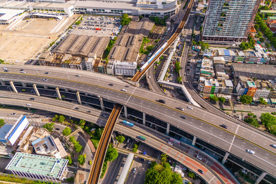 Aerial drone top view multi level junction interchange between highway, expressway and electric suburban train railroad in urban area
