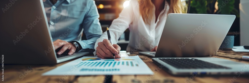 Aufkleber a close-up shot of two business professionals working together at their desks. they are reviewing da