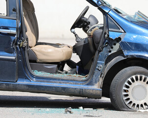 Car completely destroyed with broken windows and a flat tire after vandalism during riot