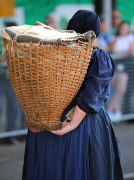 elderly lady of the Italian partisan group called PORTATRICI CARNICHE carrying a wicker basket called GERLA