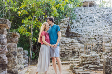 Couple, man and woman tourists at Coba, Mexico. Honeymoon Ancient mayan city in Mexico. Coba is an archaeological area and a famous landmark of Yucatan Peninsula. Cloudy sky over a pyramid in Mexico