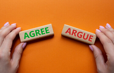 Agree or Argue symbol. Concept word Agree or Argue on wooden blocks. Businessman hand. Beautiful...