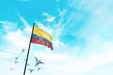 Colombia flag waving with flying doves against sunset or sunrise. Colombia flag for Republic Day and Independence Day.