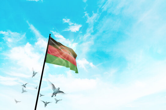 Malawi flag waving with flying doves against sunset or sunrise. Malawi flag for Republic Day and Independence Day. - Powered by Adobe