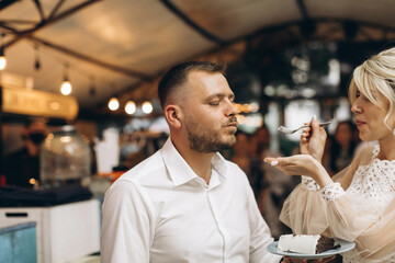 The wedding cake. The bride and groom cut off a piece of cake with a knife. The hands of the newlyweds cut the first piece of the wedding cake.