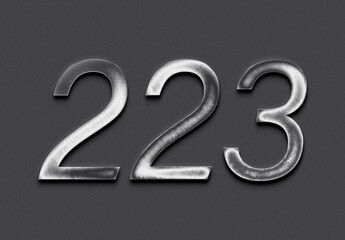 Chrome metal 3D number design of 223 on grey background.