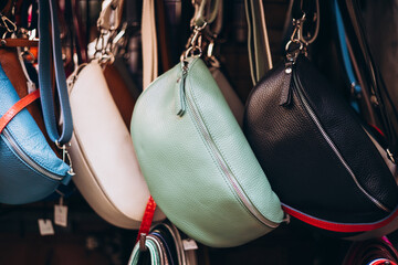 Fashion bags in a store. Close up of different leather bags on market. Modern colorful bags for...