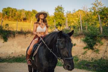 Fototapeta premium Portrait of smiling horsewoman horseback riding a horse at homestead.