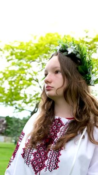 Ukrainian woman walking in fir forest, Carpathian mountains nature. Girl in traditional embroidery vyshyvanka dress, red wreath, ancient jewelry. Ukraine, freedom, ethnic national costume