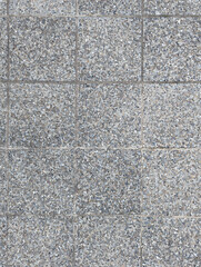 Top view of grey outdoor floor with classic square tiles with small colored washed river stones or pebbles for porches, patios, terraces and pool areas texture or background.