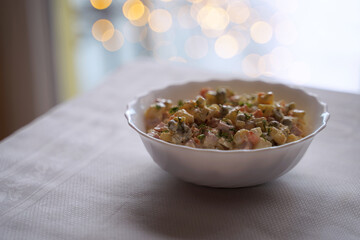 Olivier salad, traditional salad dish of post Soviet cuisine. Traditional Ukrainian food on the table with embroidered tablecloth.