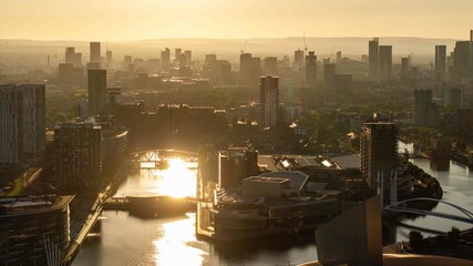 Naklejka premium The canals of Manchester bask in the golden hour sunlight, with a view towards Salford Quays