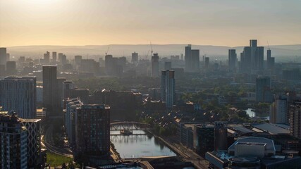 A tranquil sunrise view over Manchester's skyline with glimpses of Deansgate and Salford Quays in the warm morning light
