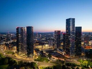 Manchester's Great Jackson Street skyscraper district illuminated at twilight with the urban...