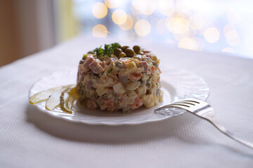 Olivier salad, traditional salad dish of post Soviet cuisine. Traditional Ukrainian food on the table with embroidered tablecloth.
