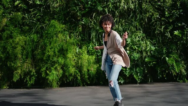 young woman lets her body move freely, embracing joy of dance in outdoor setting filled with lush greenery.moment of pure, carefree happiness.beauty of spontaneous dance and freedom of self-expression