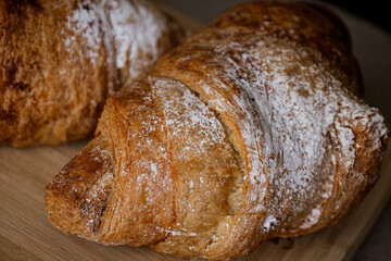 Crispy, fresh, homemade, oven-baked French croissant on a wooden plate; lots of croissants; coffee time; snack; cheat meal