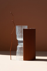 Composition of stone, paper and glass on a brown background. Minimalistic still life in calm pastel colors