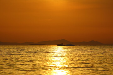 Alone sailboats at sunset. Atmospheric seascape with reflection