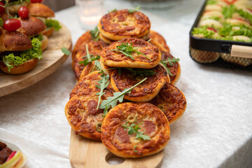 Mini pizzas with cheese and arugula on a wooden board