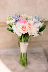 A pretty wedding bouquet on a concrete ground against a building. 