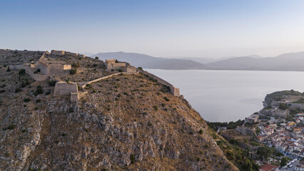 Fototapeta premium View from above on Nafplio city in Greece with port, Bourtzi fortress and blue Mediterranean sea soft focus