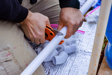 Plumber uses special scissors when installing plastic PVC water pipes