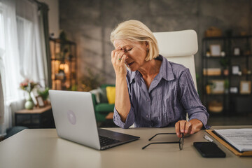Mature senior woman work from home and have eyestrain pain
