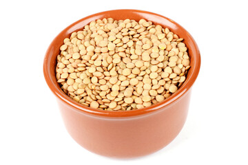 Pile of brown raw dry lentils in ceramic bowl isolated on white background
