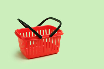 Small red shopping basket on green background